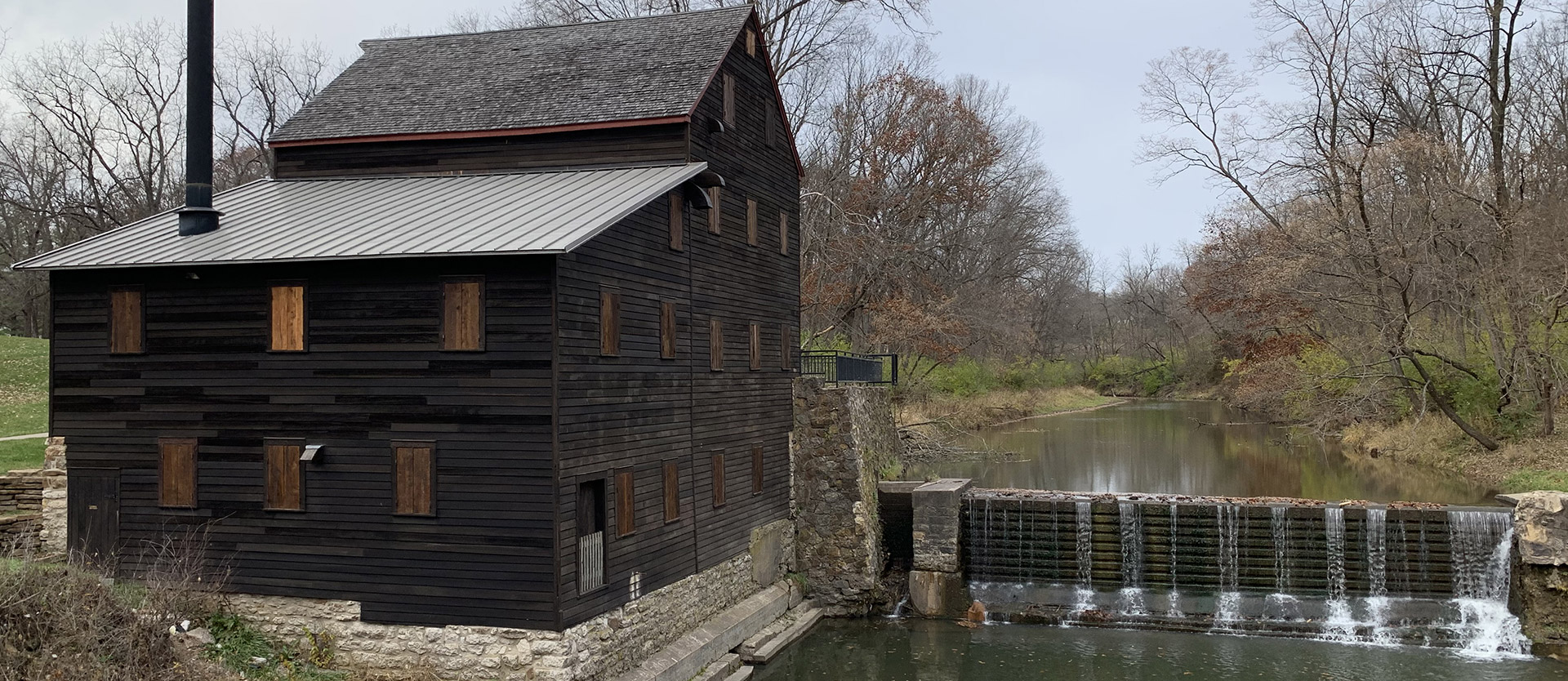 Outdoor photo of the grist mill and a dam next to it