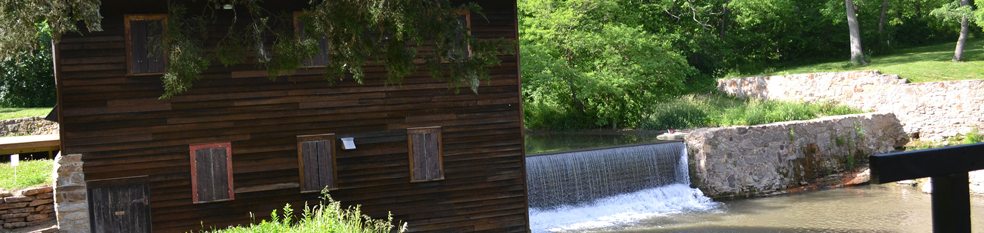 Outdoor photo of the grist mill and a dam next to it